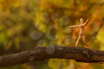 Royalty Free Photo of a Wooden Man on a Branch