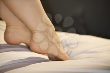 Royalty Free Photo of a Woman's Outstretched Feet on a Bed