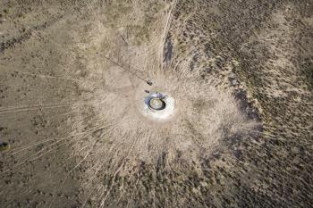 Royalty Free Photo of an Aerial View of a Livestock Watering Pump in the Middle of an Empty Field