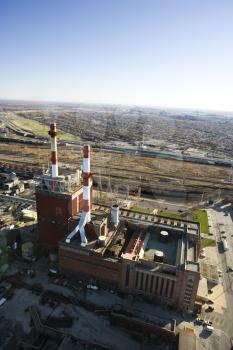 Royalty Free Photo of an Aerial View of a Factory With Smokestacks and City in the Distance