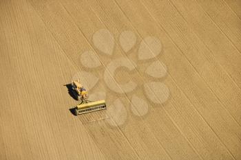 Royalty Free Photo of an Aerial of a Farmer Tilling Crop Field in Farmland, USA