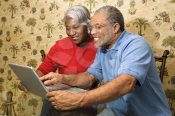 Royalty Free Photo of an Older Couple Looking at a Laptop at Home