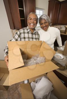Royalty Free Photo of a Couple Packing Their Kitchen into Boxes