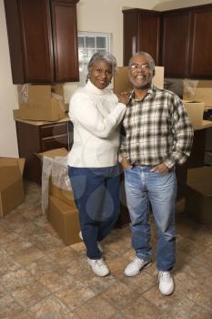 Royalty Free Photo of a Couple Standing in a Kitchen Full of Boxes