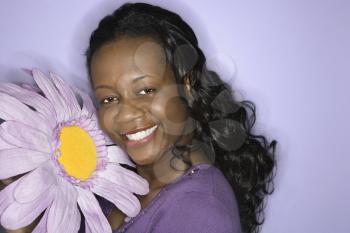 Royalty Free Photo of a Woman Holding a Big Purple Fake Flower