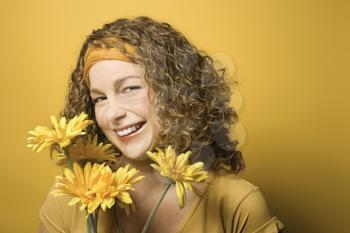 Royalty Free Photo of a Smiling Young Woman Holding Flowers