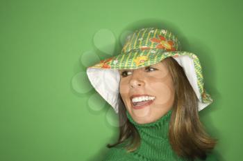 Royalty Free Photo of a Woman on a Green Background Wearing a Floppy Hat