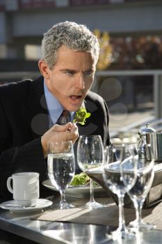 Royalty Free Photo of a Businessman Eating a Salad