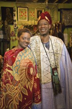 Royalty Free Photo of a Smiling Man and His Daughter Wearing Traditional African Clothing