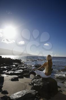 Royalty Free Photo of a Woman Meditating on a Rocky Beach in Maui Hawaii