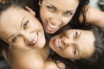 Royalty Free Photo of Three Women Embracing Each Other Looking Up and Smiling