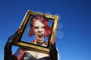Royalty Free Photo of a Woman Holding an Empty Frame Around Her Head