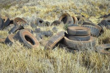 Royalty Free Photo of Old Dirty Abandoned Tires in a Field