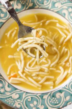 Royalty Free Photo of a Bowl of Chicken Noodle Soup With a Spoon
