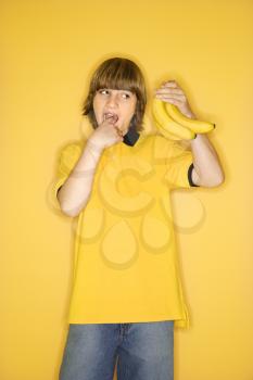 Royalty Free Photo of a Boy Holding a Bunch of Bananas