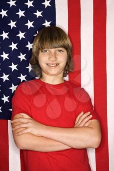 Royalty Free Photo of a Smiling Boy Standing in Front of an American Flag