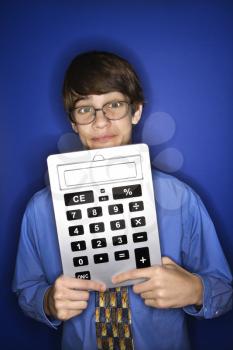 Royalty Free Photo of a Teen Boy Wearing Eyeglasses and a Necktie Holding an Over-Sized Calculator