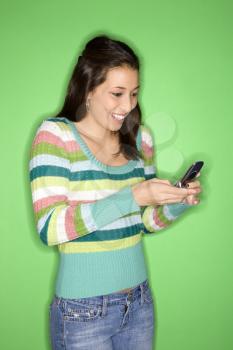 Royalty Free Photo of a Smiling Teen Girl Dialing on Her Cellphone Smiling