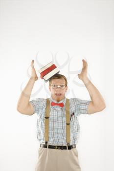 Royalty Free Photo of a Man Dressed Like a Nerd With Books Sliding off His Head