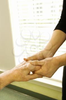 Royalty Free Photo of a Nurse Massaging Arthritic Hands of an Elderly Man 