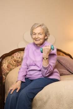 Royalty Free Photo of an Elderly Woman in Her Bedroom at a Retirement Community Lifting Weights
