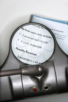 Royalty Free Photo of a Vision Magnifying Glass Used to View Health Insurance Information