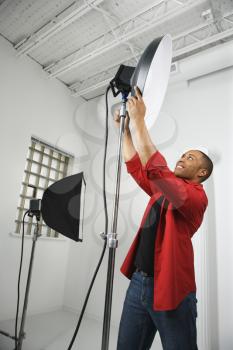 Royalty Free Photo of an African American Man Adjusting Studio Lights
