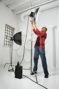 Royalty Free Photo of an African American Man Adjusting Studio Lights
