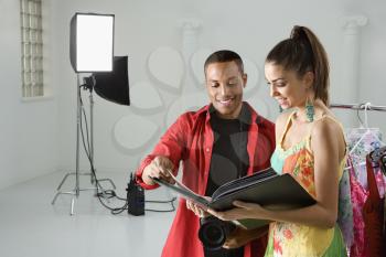 Royalty Free Photo of a Photographer and Model Looking at a Portfolio