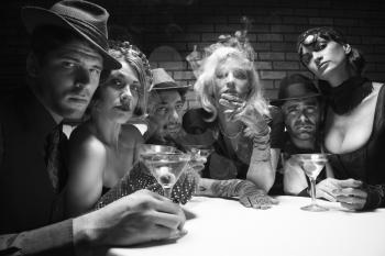 Royalty Free Photo of Males and Females Sitting Drinking and Smoking