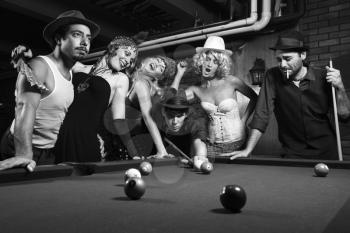 Royalty Free Photo of a Retro Shot of a Group of People Playing Pool