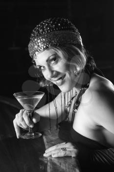 Royalty Free Photo of a Woman Sitting at a Retro Bar Drinking a Martini