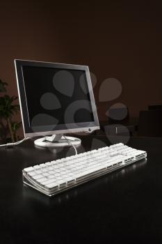 Computer monitor and keyboard on desktop.
