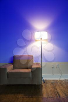 Modern chair and floor lamp with blue cast from projection.