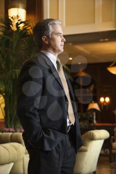 Royalty Free Photo of a Businessman Standing in a Hotel Lobby