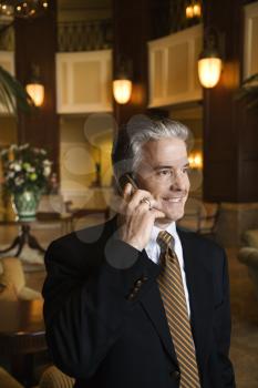 Royalty Free Photo of a Businessman Talking on a Cellphone in a Hotel Lobby