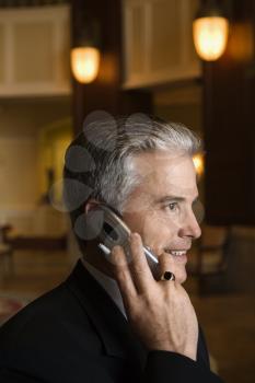 Royalty Free Photo of a Businessman Talking on Cellphone in a Hotel Lobby