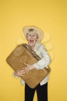 Royalty Free Photo of an Older Woman Holding a Suitcase