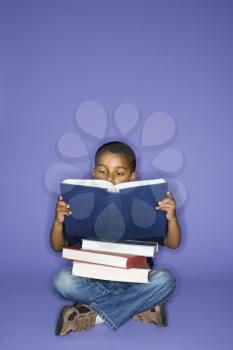 Royalty Free Photo of a Boy Sitting Reading Books
