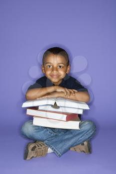 Royalty Free Photo of a Boy Sitting With a Stack of Books