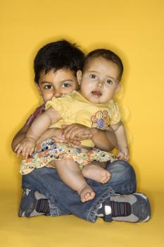 Royalty Free Photo of a Little Boy Holding His Baby Sister