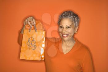 Royalty Free Photo of an Older Female Holding a Gift Bag