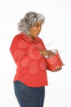 Royalty Free Photo of an Older Woman With Her Hand in a Jar