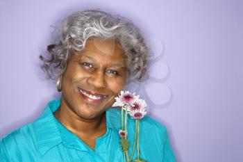 Royalty Free Photo of an Older Woman Holding Flower Smiling