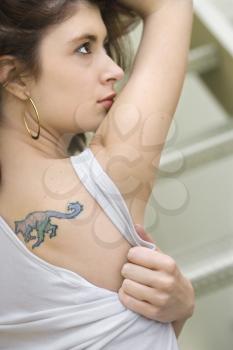 Portrait of attractive young redhead Caucasian woman with tattoo on shoulder.