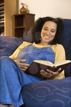 Royalty Free Photo of a Young Pregnant Woman Reading a Book