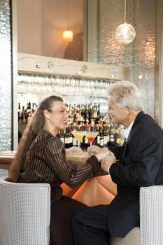 Royalty Free Photo of a Couple Sitting at a Bar Holding Hands