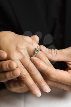 Royalty Free Photo of a Man Putting an Engagement Ring on a Woman's Hand