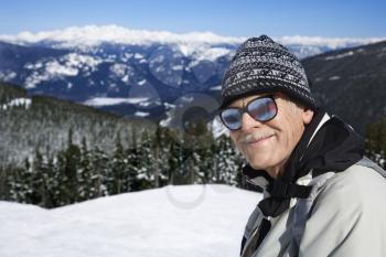 Royalty Free Photo of an Older Male Skier in Goggles Posing on a Mountain