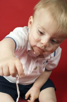 Portrait of Caucasian male child playing with string.